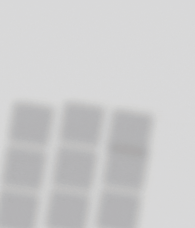A minimalist pattern of light gray squares arranged in a grid on a plain white background, with a blurred visual effect.