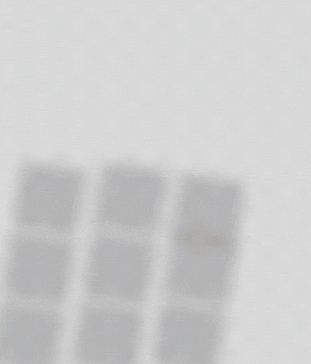 A person types on a laptop with a calculator, notepad, and pen nearby on a white desk, suggesting a work or study setting.