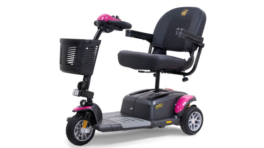 A three-wheeled mobility scooter, such as the BuzzAround EX 3-Wheel Scooter, featuring a front basket, black padded seat, armrests, and stylish pink accents on the fenders.