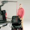 Woman holding remote for Curb Sider lift in back of pickup truck attached to power wheelchair