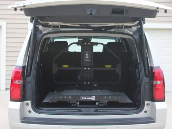 White vehicle with trunk door open showing Joey lift folded up inside of trunk
