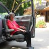 woman in red shirt on turning seat exiting a vehicle
