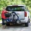 Woman lowering scooter with Out Sider Lift on white SUV