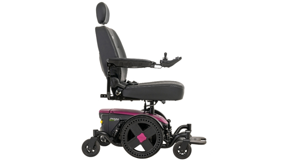 A side view of a black and purple Jazzy EVO 614 Power Wheelchair featuring a padded seat, armrests, joystick control, and headrest.