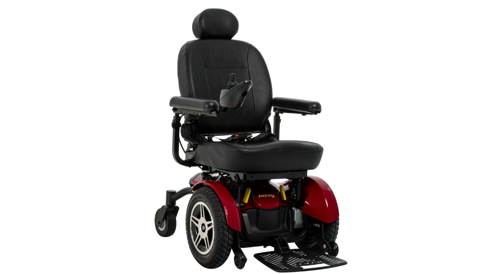Jazzy Elite HD Power Wheelchair in red and black with padded seat, armrests, headrest, joystick control, and footrest on a white background.