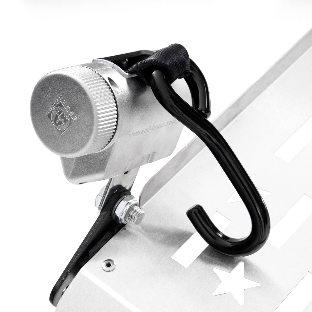 Close-up of a Harmar Fusion Lift (AL300-MW) metal lock device featuring a combination dial and black hook, secured to a metallic surface with bolts and cut-out star shapes.