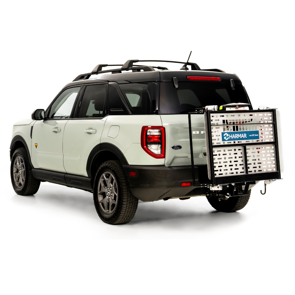 A white SUV with a Harmar Fusion Lift (AL300-MW) attached to its rear hitch, viewed from the back left side against a white background.
