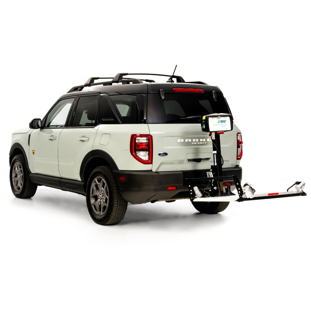 A white Ford Bronco Sport SUV with a rear-mounted Harmar Fusion Lift (AL300-MW) bike rack attached, carrying a single bicycle tire and license plate.