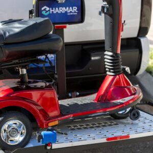 A red mobility scooter is secured on a Harmar Extra Large Fusion Lift (AL301XL), which is mounted to the back of a vehicle. The lift displays the Harmar logo on a sign in the background.