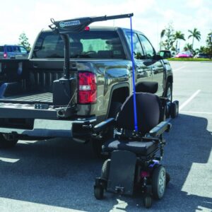 A pickup truck with a Harmar Hoist Lift with Power Lift and Rotate (AL425) is unloading a power wheelchair in a sunny parking lot.
