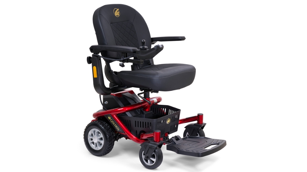 A red LiteRider Envy Power Wheelchair featuring a black cushioned seat, armrests, joystick control, footrest, and a small storage basket beneath the seat.