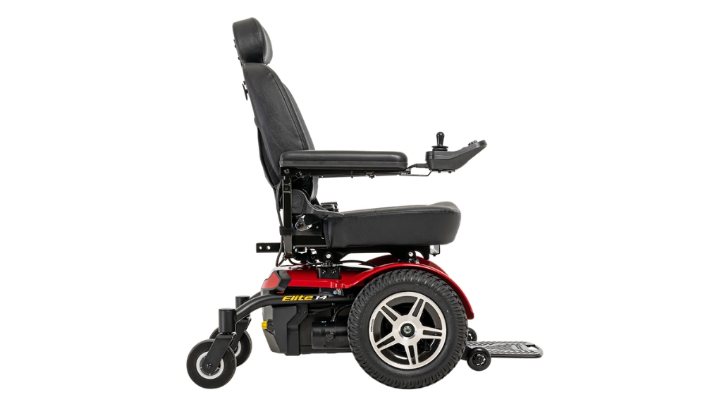 Side view of a Jazzy Elite 14 Power Wheelchair in black and red, featuring a padded seat, armrests, footrest, and joystick control on the right arm.