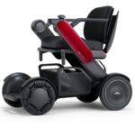 The C2 Model - Portable Electric Wheelchair is a modern, compact mobility aid featuring a red side panel, black cushioned seat, and large all-terrain wheels.