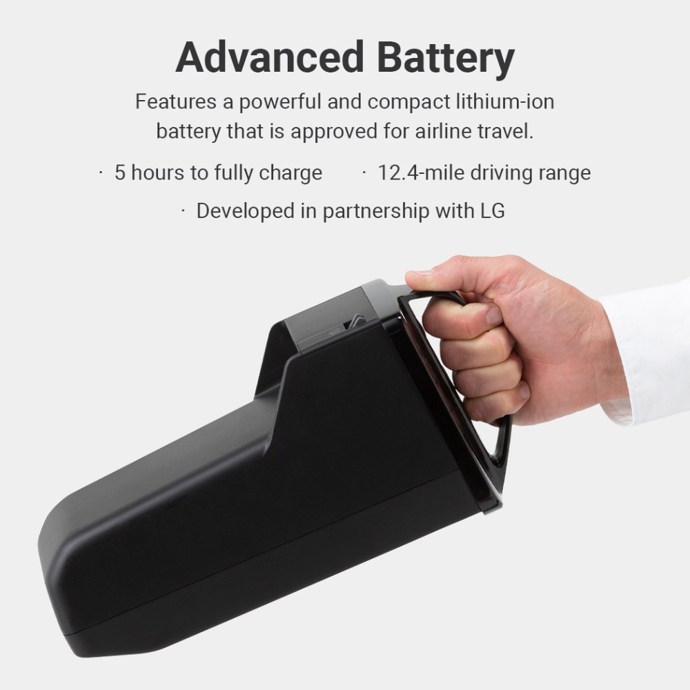A hand holds a compact black lithium-ion battery, designed for the C2 Model - Portable Electric Wheelchair; it is powerful, airline-approved, offers a 5-hour charge time and a 12.4-mile range, and is developed in collaboration with LG.