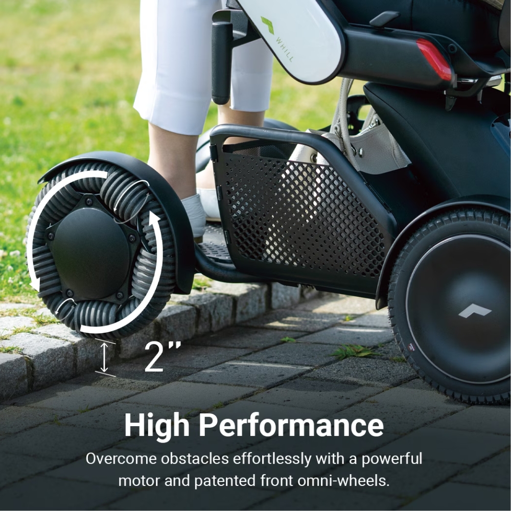 Using the WHILL Model C2 High Back mobility device, which features omni-wheels, a user climbs a 2-inch curb—demonstrating the product’s capability to surmount small obstacles.