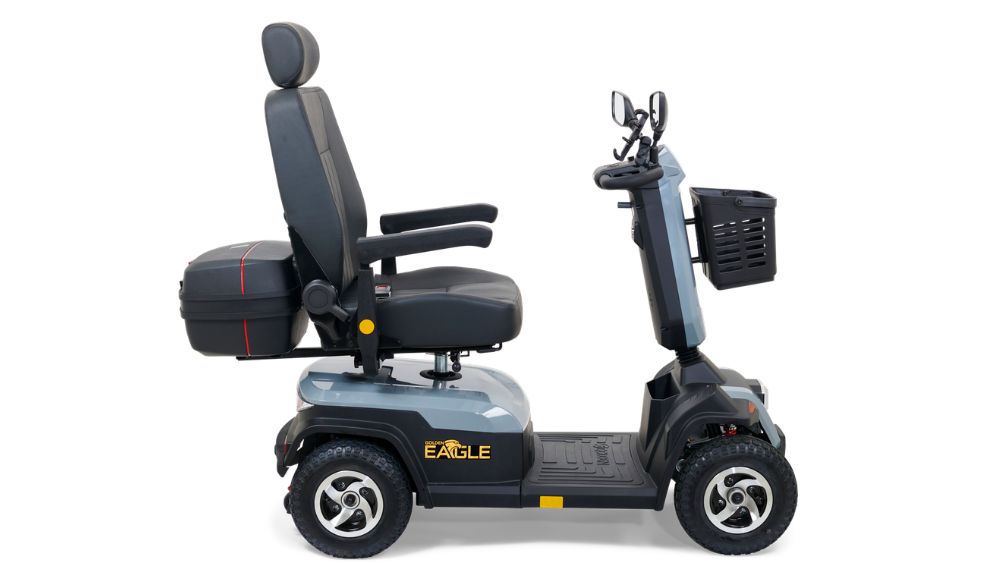 The Eagle 4-Wheel Scooter is a gray mobility scooter featuring four wheels, a cushioned seat, backrest, armrests, and a front basket, shown in a side profile view.