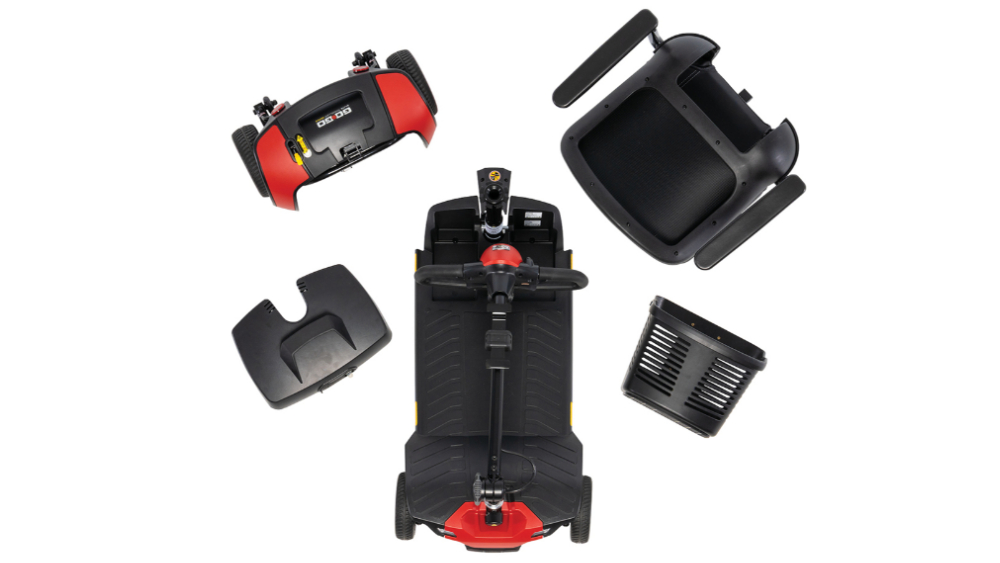 Disassembled Go Go Elite Traveller Gen 3 mobility scooter shown from above, with the base, seat, rear wheels, battery cover, and basket laid out separately.