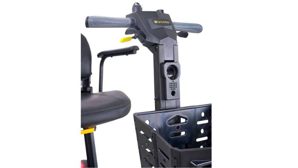 Close-up view of a Buzzaround CarryOn 4-Wheel Scooter handlebar with controls, part of a seat, and a front basket visible.