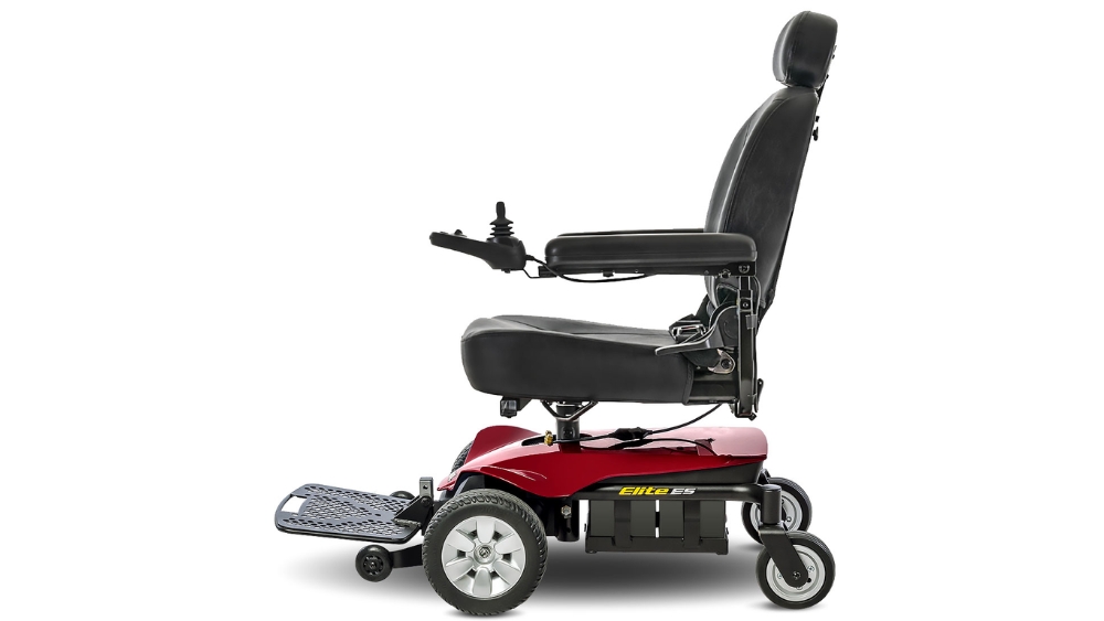 Side view of a red and black Jazzy Elite ES Power Wheelchair featuring a joystick control, footrest, and padded seat.