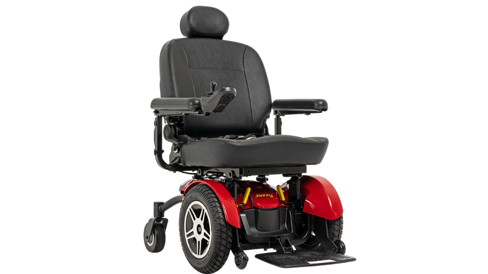 A Jazzy Elite 14 Power Wheelchair in red and black, featuring armrests, a cushioned seat, a headrest, and joystick control, displayed against a plain white background.