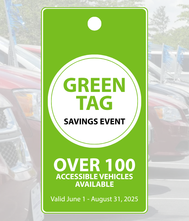 Bright green hanging tag sign reads: “Green Tag Savings Event. Over 100 accessible vehicles available. Valid June 1 – August 31, 2025,” with cars visible in the background.