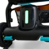 Close-up of the lower section of the Ally Power Wheelchair, featuring a glowing green vertical light, part of a wheel, and a mesh basket with brown trim visible in the background.