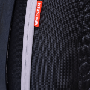 Close-up of a textured black Ally Pro Power Wheelchair bag, featuring a vertical light grey zipper and a red tag labeled GOLDEN.