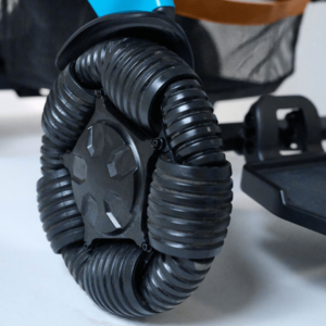Close-up of an omnidirectional black rubber wheel with segmented treads attached to the Ally Pro Power Wheelchair.