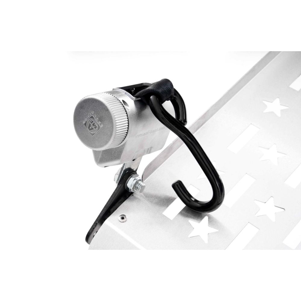 Close-up of a metallic bike lock attached to a perforated metal surface with star-shaped cutouts, featuring a black hook and a silver combination dial—reminiscent of the robust security mechanisms used in the Harmar Fusion Lift (AL300-MW) platform lift systems.
