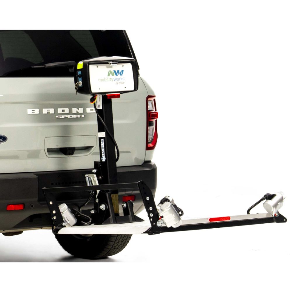 A vehicle equipped with the Harmar Fusion Lift (AL300-MW) attached to the rear bumper, designed for transporting a mobility device such as a wheelchair or scooter. For enhanced accessibility, some models also offer a side entry platform lift for convenient boarding and exiting.