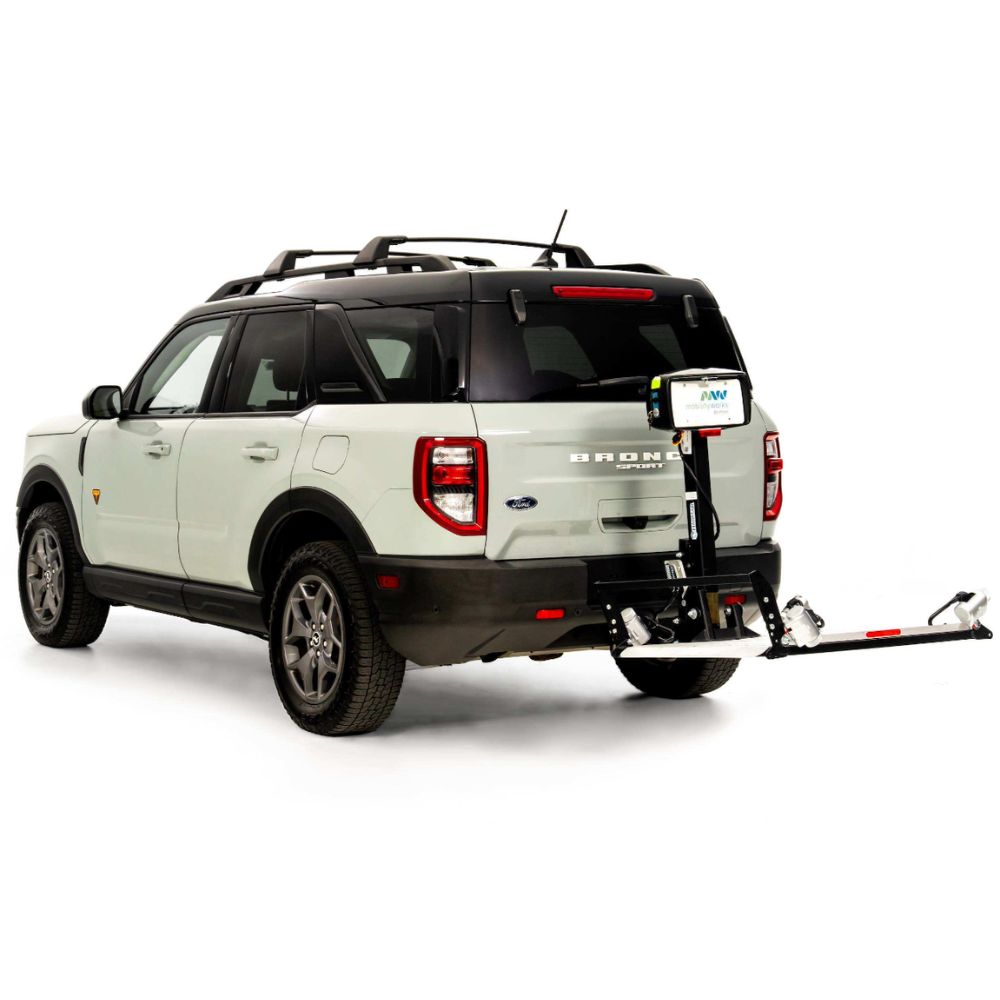 A white Ford Bronco SUV with a black roof is equipped with a Harmar Fusion Lift (AL300-MW) attached to its rear hitch, complemented by a convenient side entry platform lift for enhanced accessibility.