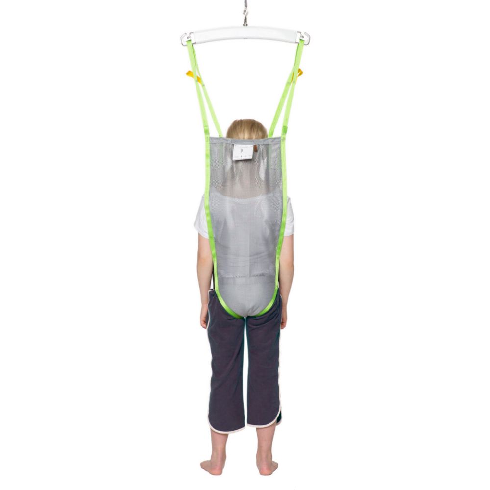 A child stands in a Human Care Activity Sling, suspended from a metal frame and viewed from the back.