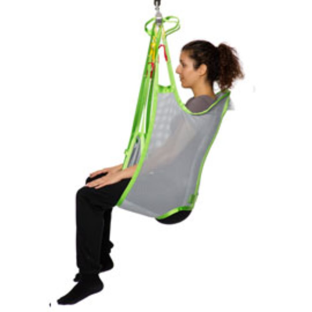 A person sits in a Human Care Bath Sling-Polyester Net patient lift sling, suspended from a hoist, with legs hanging down and arms resting on the sides.