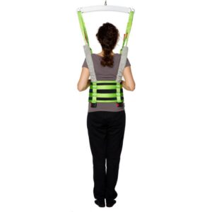 A person wearing a green safety harness, identified as the Human Care Multi Sling, is suspended from overhead supports and shown from the back against a plain white background.
