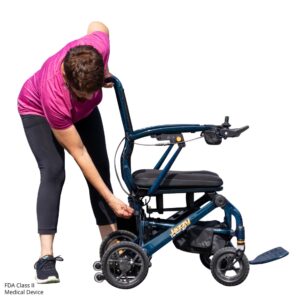 A person in athletic wear adjusts the mechanism on a Jazzy Carbon 27 Power Wheelchair. "FDA Class II Medical Device" text appears in the bottom left corner.
