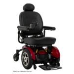 A black and red Jazzy Elite HD Power Wheelchair equipped with padded armrests, a headrest, footplate, and joystick control. This wheelchair features large rear wheels and is classified as an FDA Class II medical device.