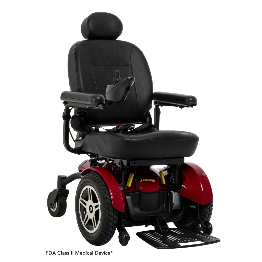 A black and red Jazzy Elite HD Power Wheelchair equipped with padded armrests, a headrest, footplate, and joystick control. This wheelchair features large rear wheels and is classified as an FDA Class II medical device.
