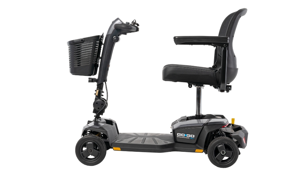 A Go Go® Endurance AL+ 4-Wheel Scooter in black, featuring four wheels, a front basket, padded seat, and armrests, displayed in side profile against a white background.