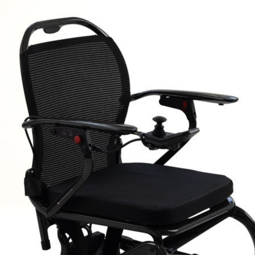 Black Monarch Mobility MM60 Carbon motorized wheelchair with a mesh backrest, padded seat, and a joystick controller on the armrest.