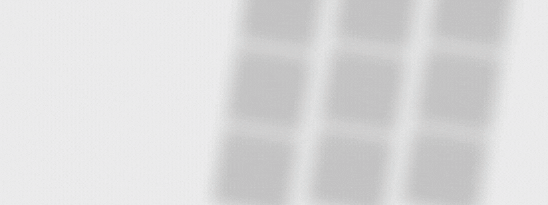 Three blurry, vertical gray lines are seen against a plain white background.