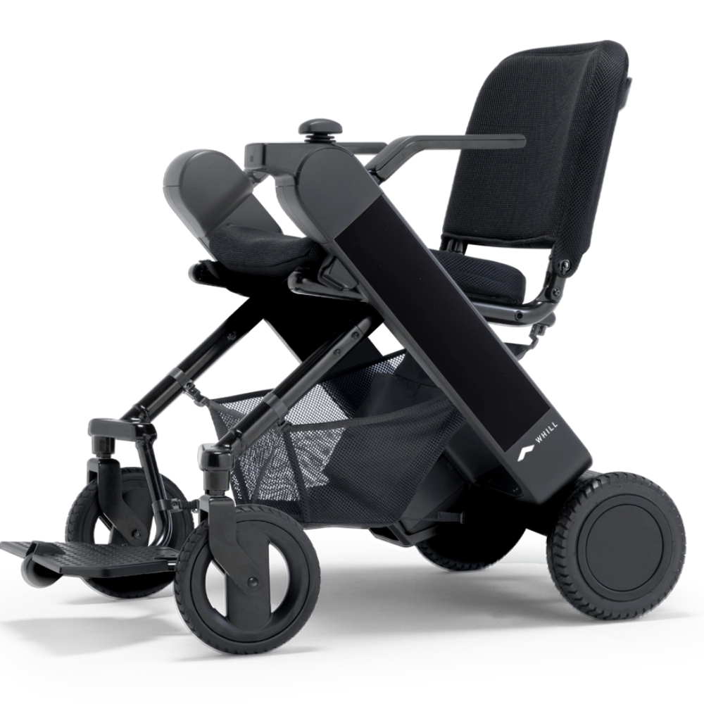 WHILL Model F folding, lightweight electric wheelchair with a black frame, mesh seat, armrests, footrest, and large rear wheels, shown on a white background.