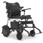 Modo Breeze electric wheelchair with a black seat, padded armrests, joystick control on the right armrest, and large rear wheels. The Modo brand is visible on the headrest.
