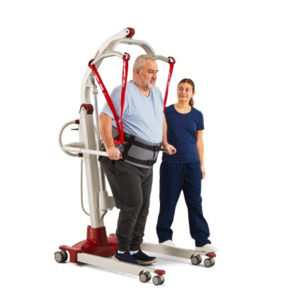 An older man uses the Molift Rgo Ambulating Vest with a patient lift for support as a healthcare worker stands nearby, assisting and monitoring him.