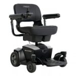 The Go Chair Power Wheelchair features a black frame, joystick control, padded seat, armrests, and a footrest. The chair displays the signature Pride and Go Chair logos.