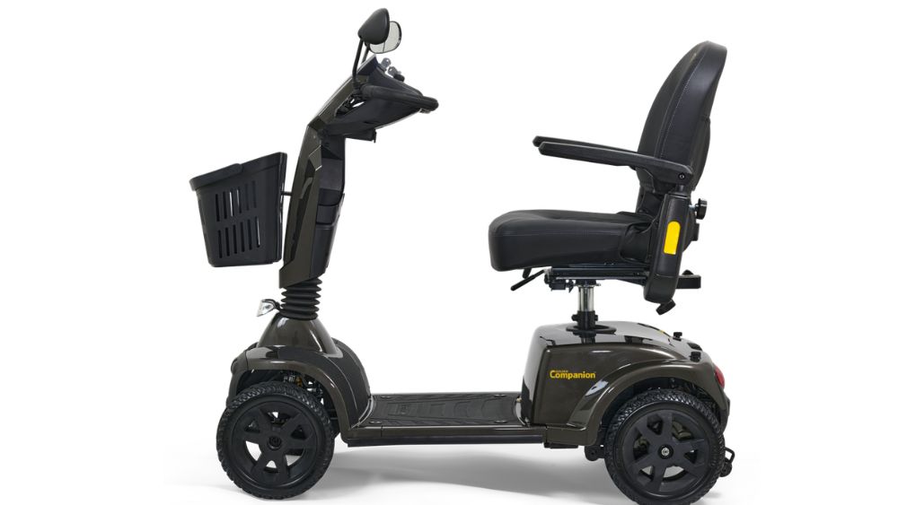 The Companion 4-Wheel Scooter, featuring a front basket, padded seat with armrests, and easy-grip handlebars, is shown in profile against a white background.