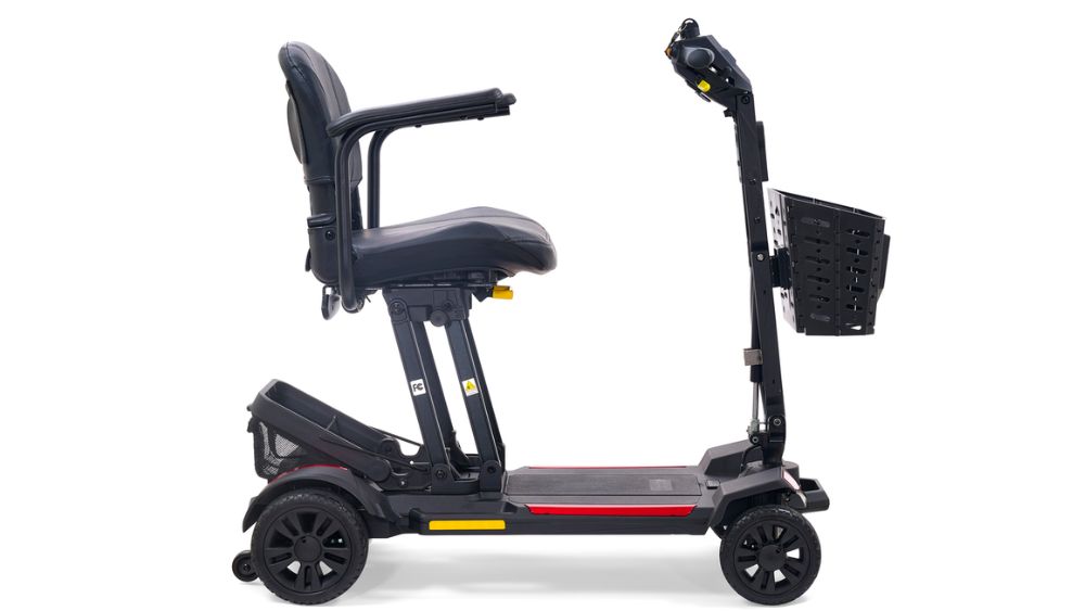 A side view of the Buzzaround CarryOn 4-Wheel Scooter in black is shown against a white background, featuring four wheels, a padded seat with armrests, a control panel, and a front basket.