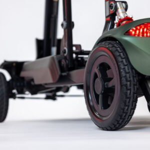 Close-up of the rear wheel, chassis, and red taillight of a Monarch Mobility Smarti Plus mobility scooter.