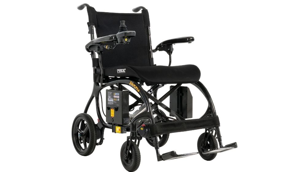 The Jazzy Carbon 27X Power Wheelchair, featuring a sleek black design, joystick control, padded seat, and footrests, is displayed on a white background.