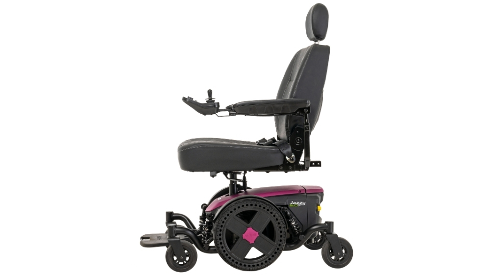 Side view of a black and purple Jazzy EVO 614 Power Wheelchair featuring a headrest, padded seat, armrests, and joystick control.