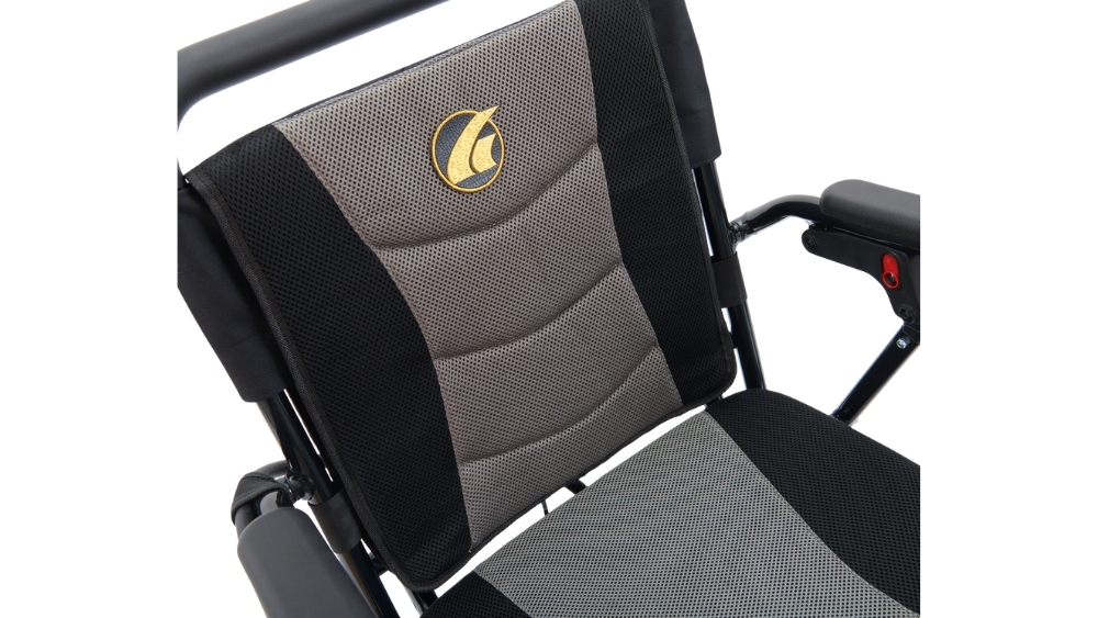 Close-up of the Stride Folding Power Wheelchair’s backrest and seat, featuring black and gray mesh fabric and a gold logo on the backrest. The image also shows the armrest and part of the wheelchair frame.